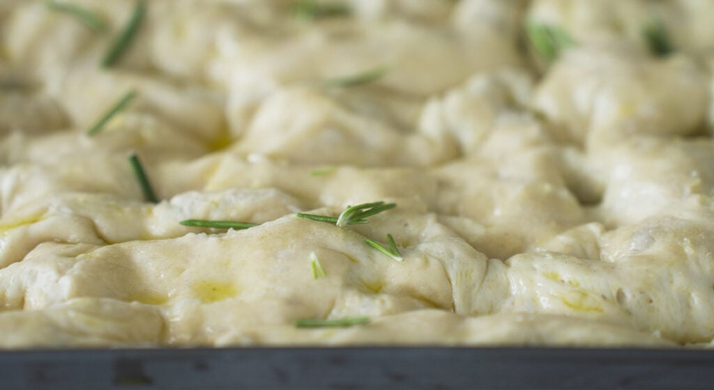 uncooked dough sprinkled with salt, rosemary and garlic