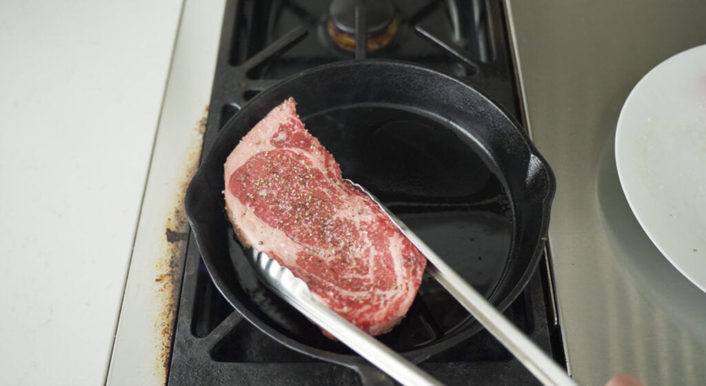 placing ribeye in pan