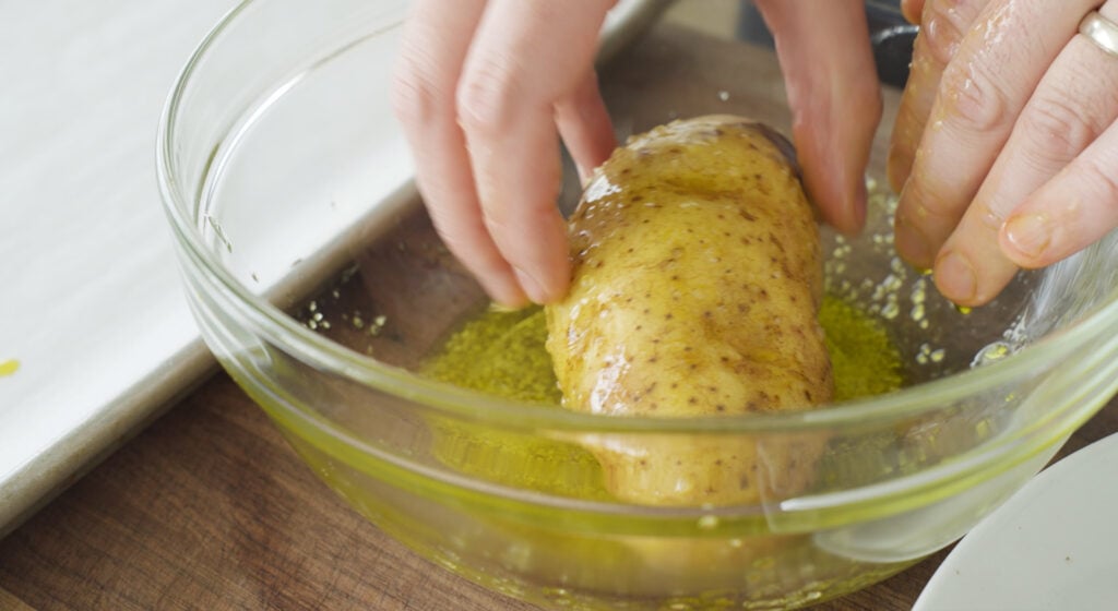 Rolling potatoes in oil mixture