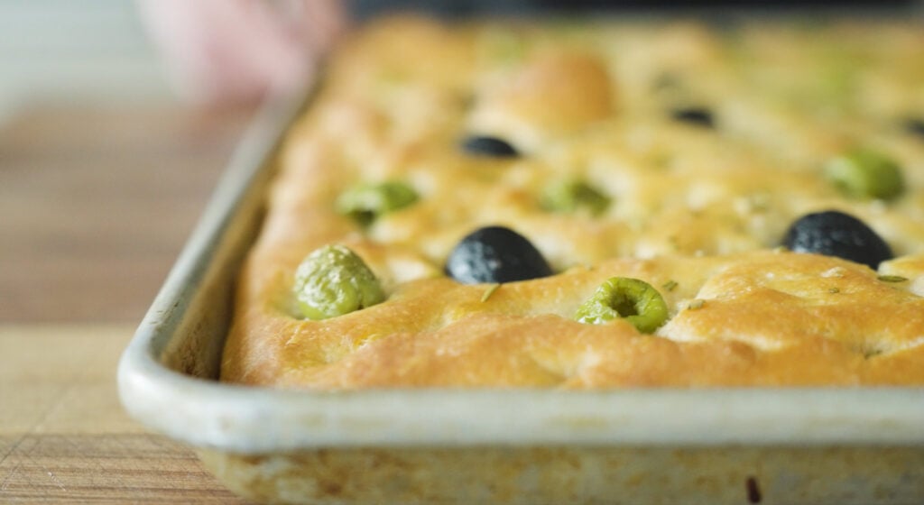 Cooked, golden brown focaccia in pan
