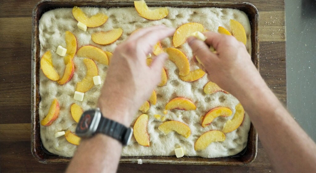 adding sliced peaches to dough