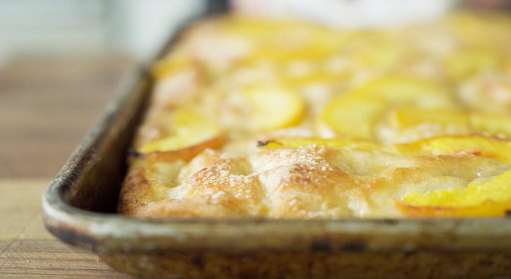 Baked and browned peach focaccia in pan