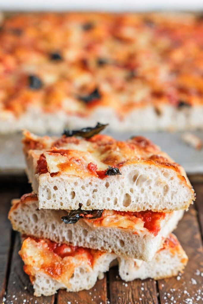 A stack of focaccia pizza slices ready to serve.