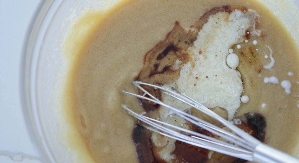 adding milk to a pumpkin bread batter