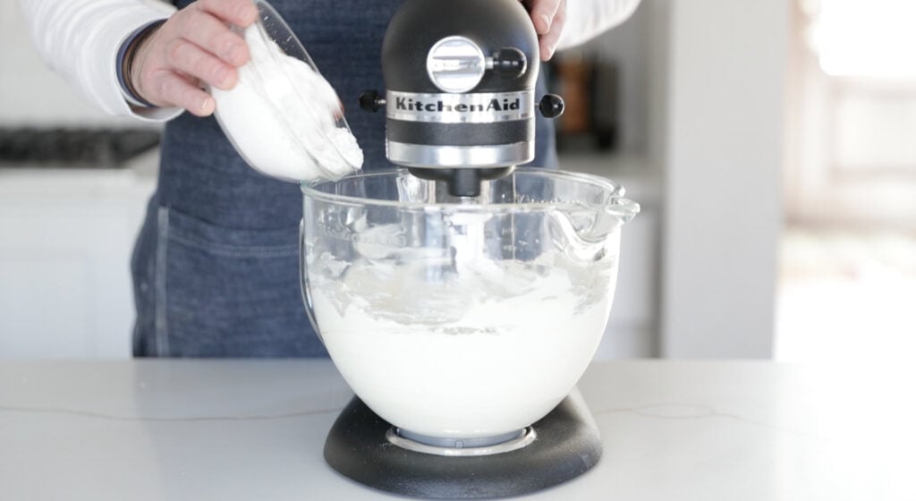 adding powdered sugar to a stand mixer