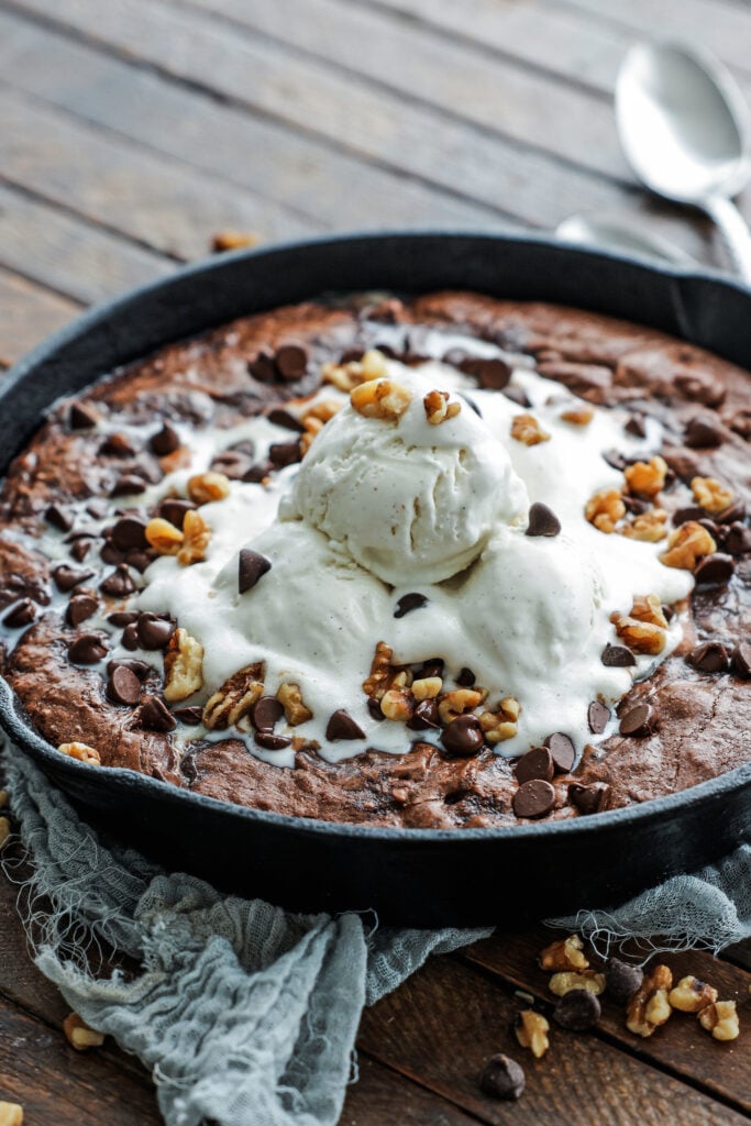 Skillet brownie topped with melty vanilla ice cream