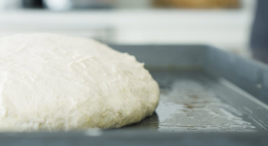 dough resting on oiled pan