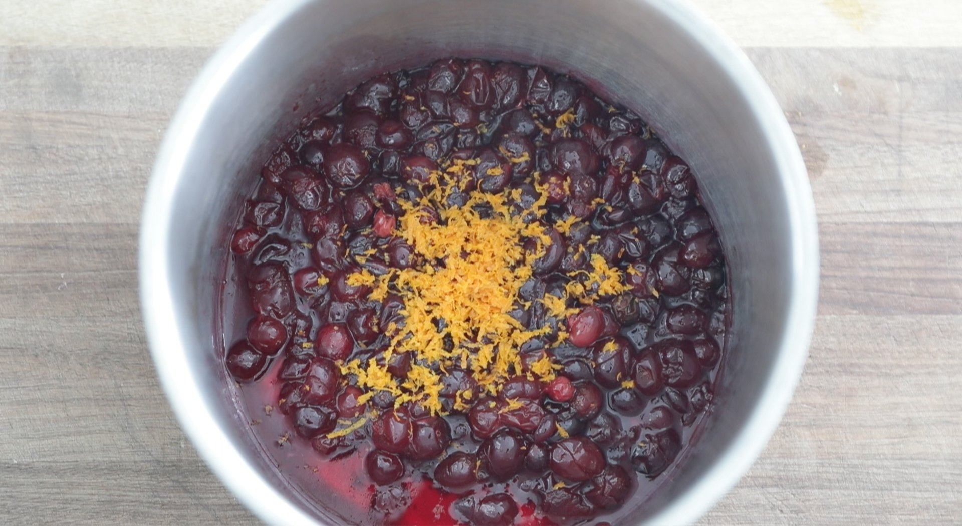 adding orange zest to cranberries