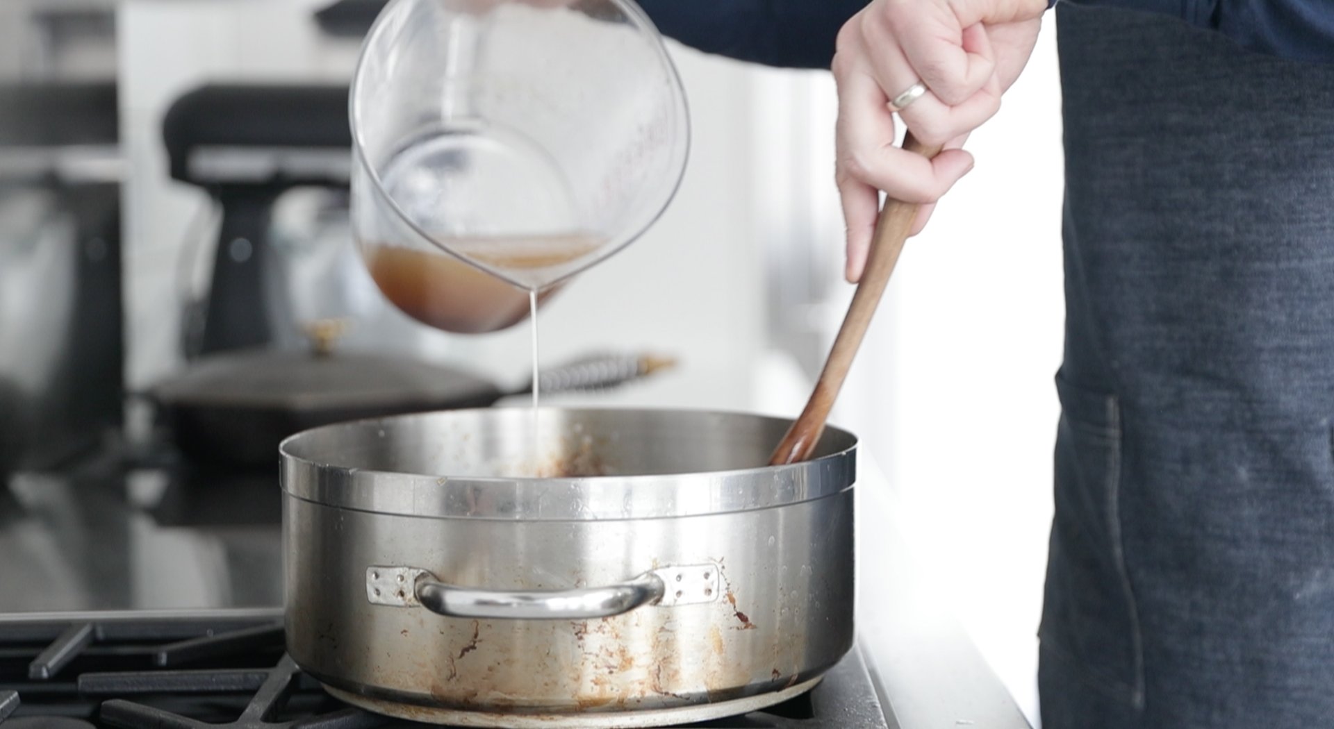 adding chicken stock to a pot with roux and vegetables