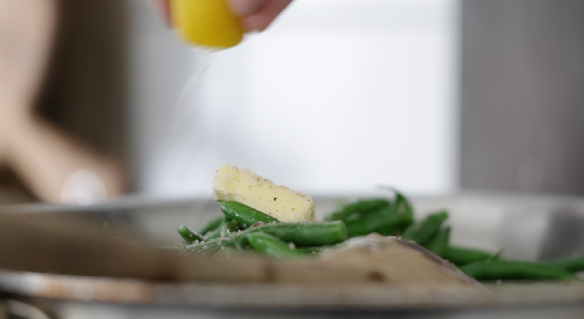 squeezing lemon juice onto green beans