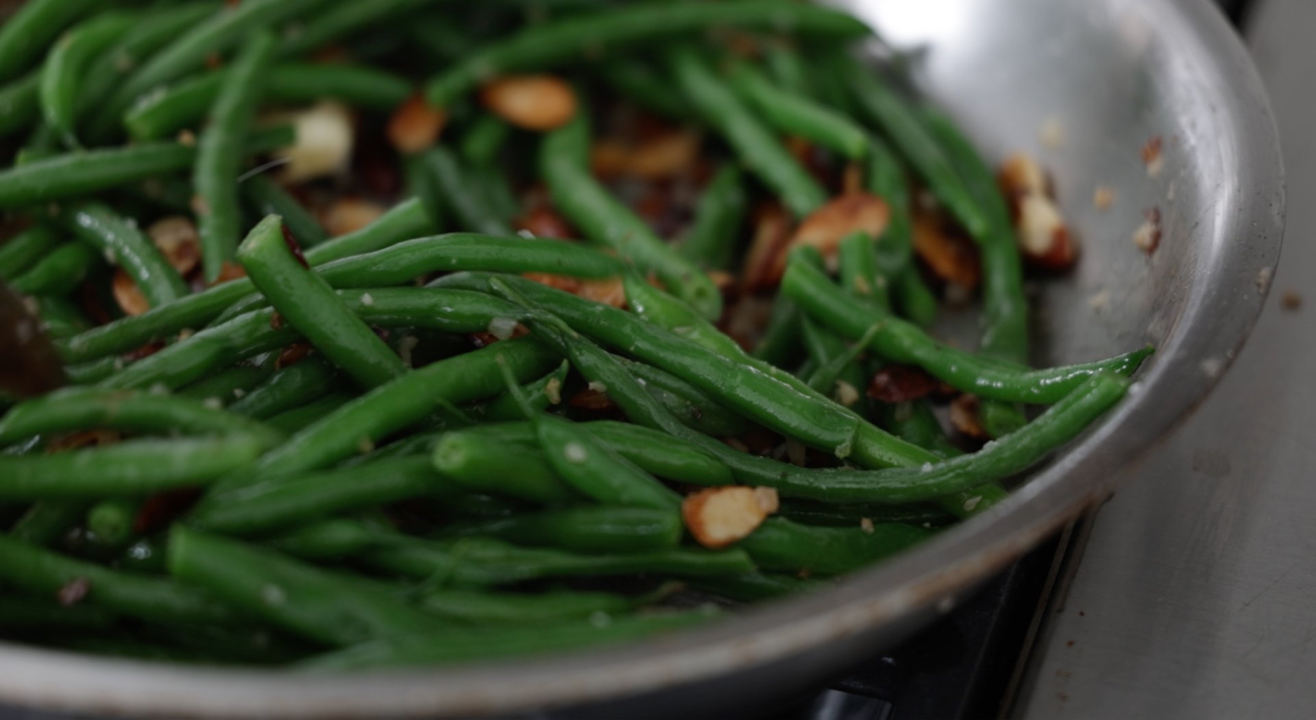 mixing green beans with almonds