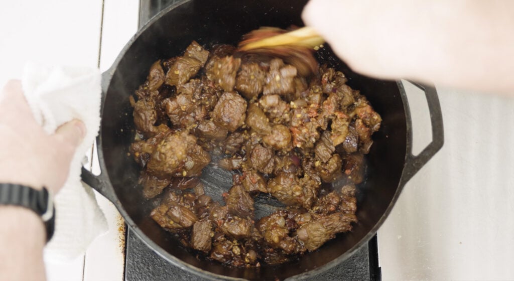 stiring beef in cast iron pot