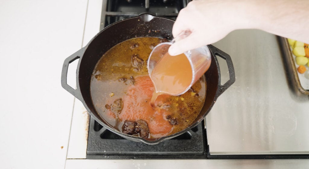 adding beef stock to the pot