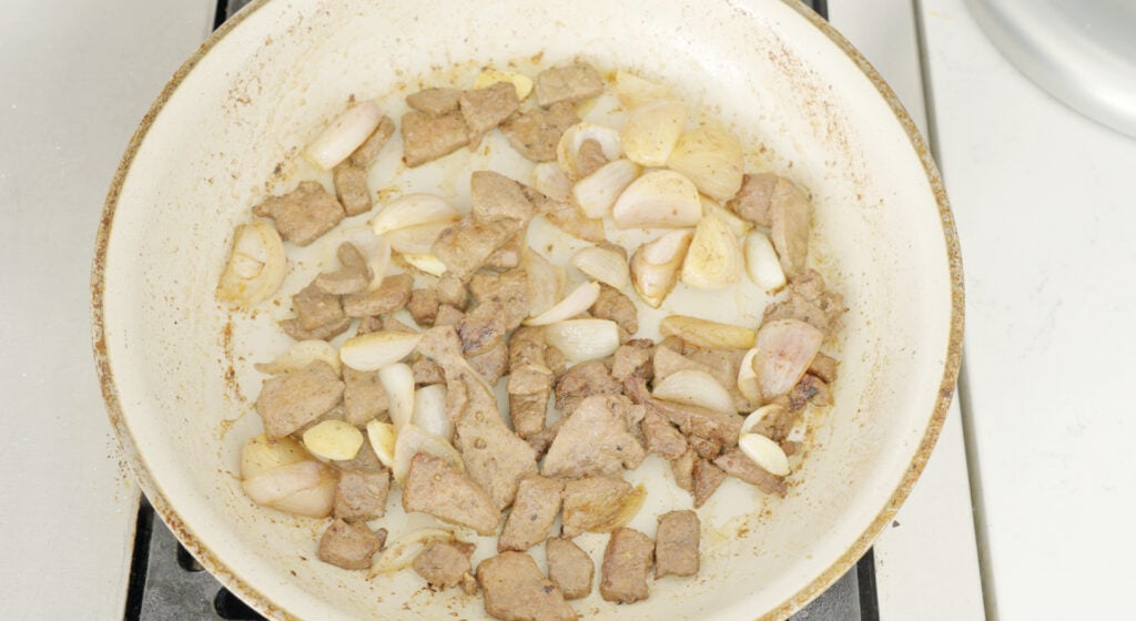Garlic and shallots in pot with livers