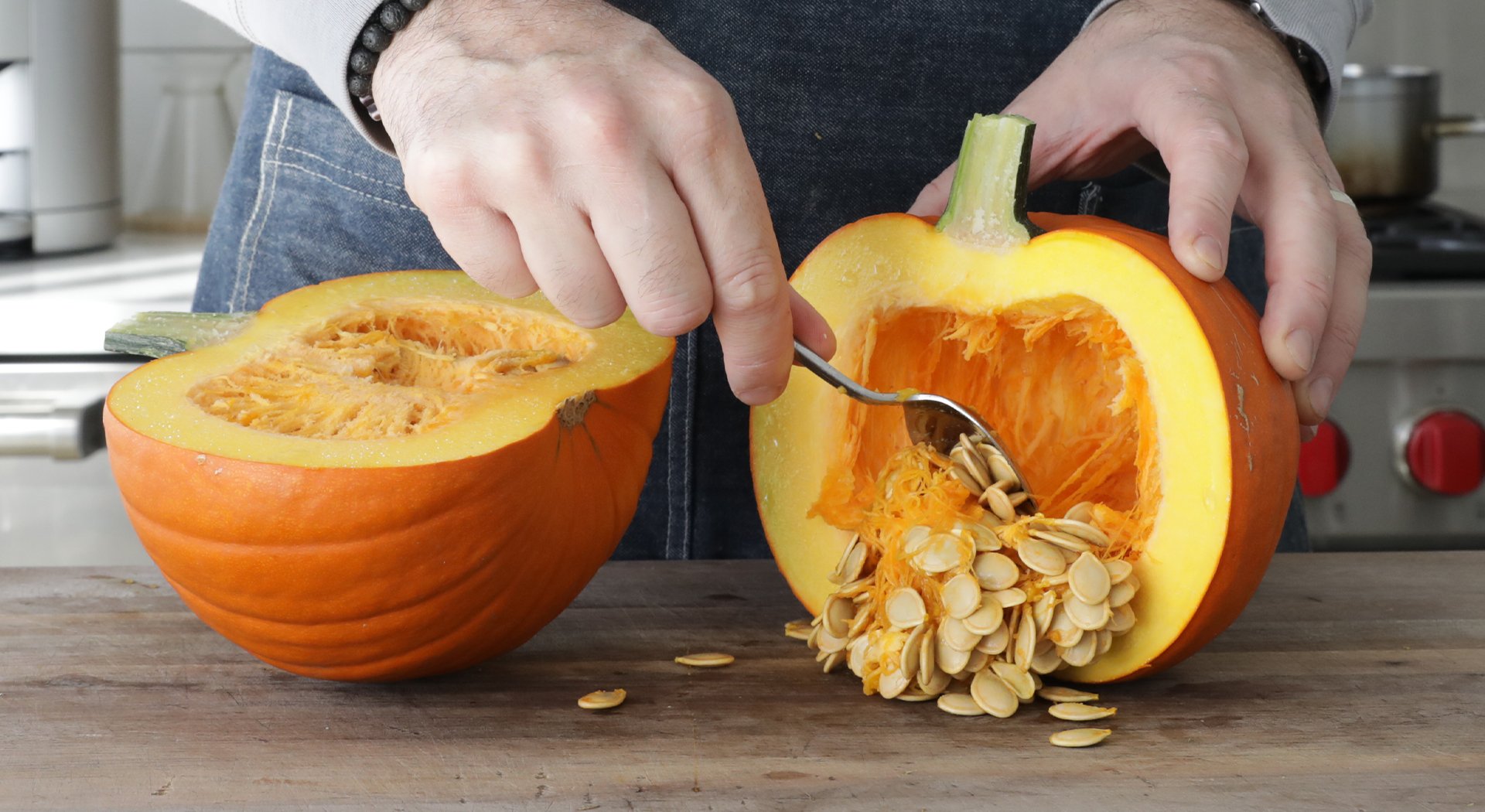 scooping pumpkin seeds out of a pumpkin