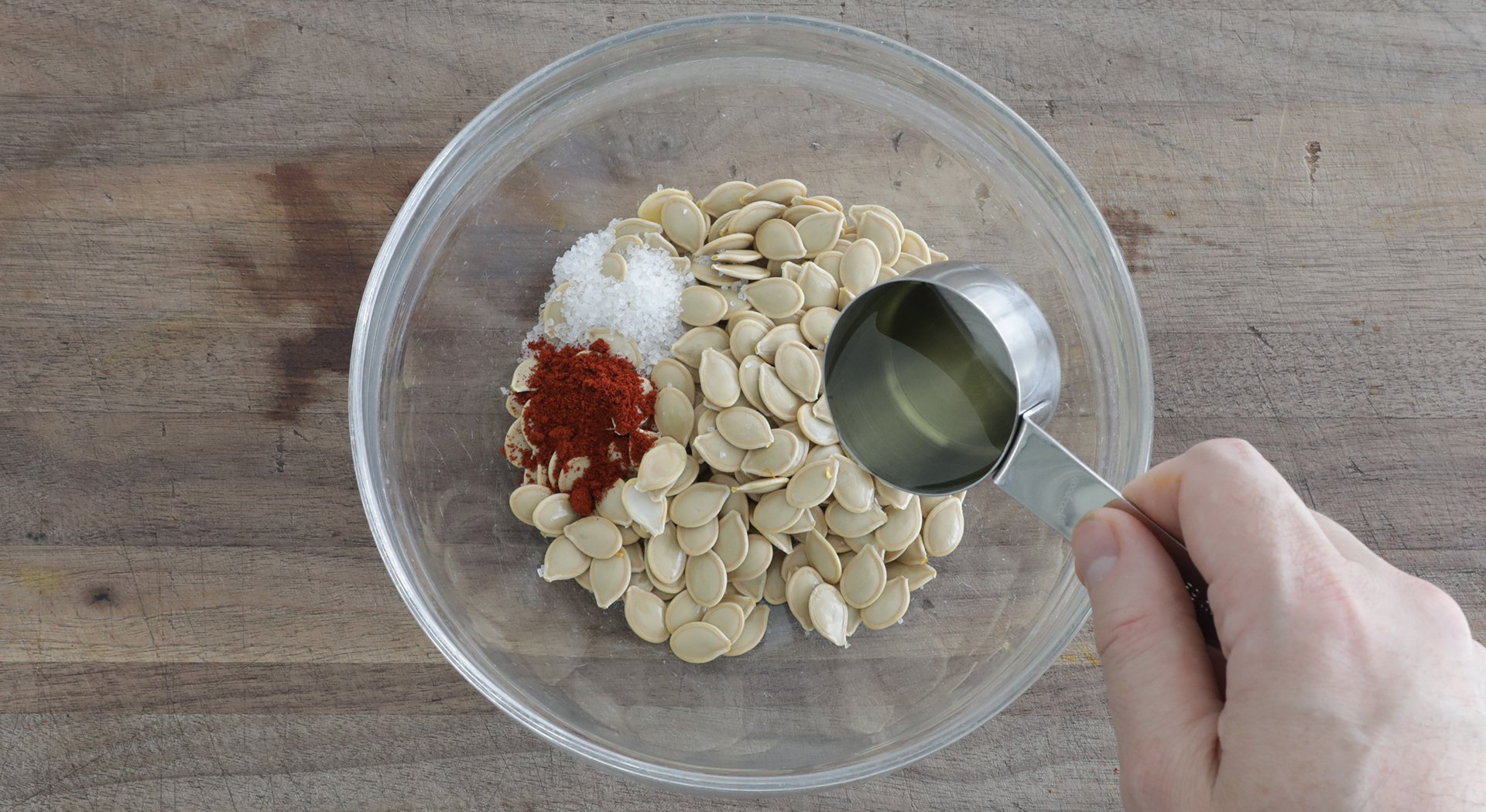 mixing pumpkin seeds with oil and seasonings