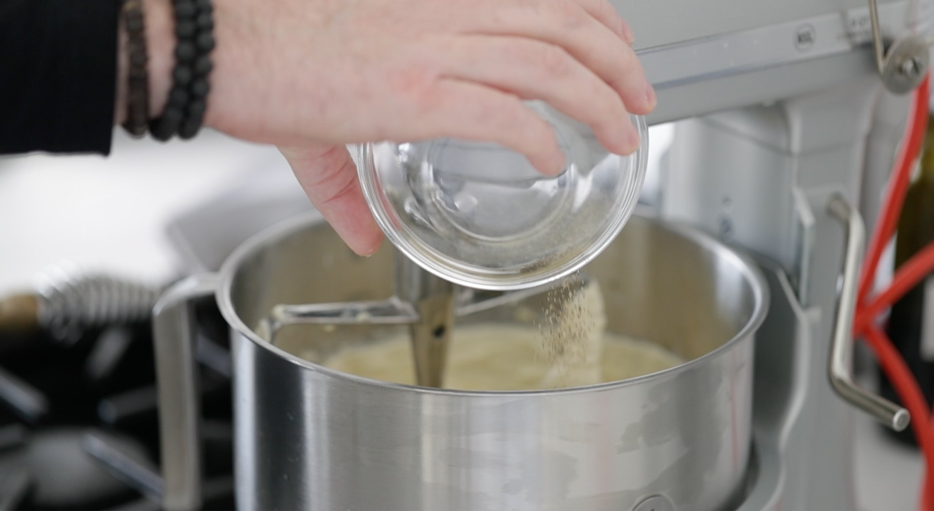 pouring herbs into a mixer with butter