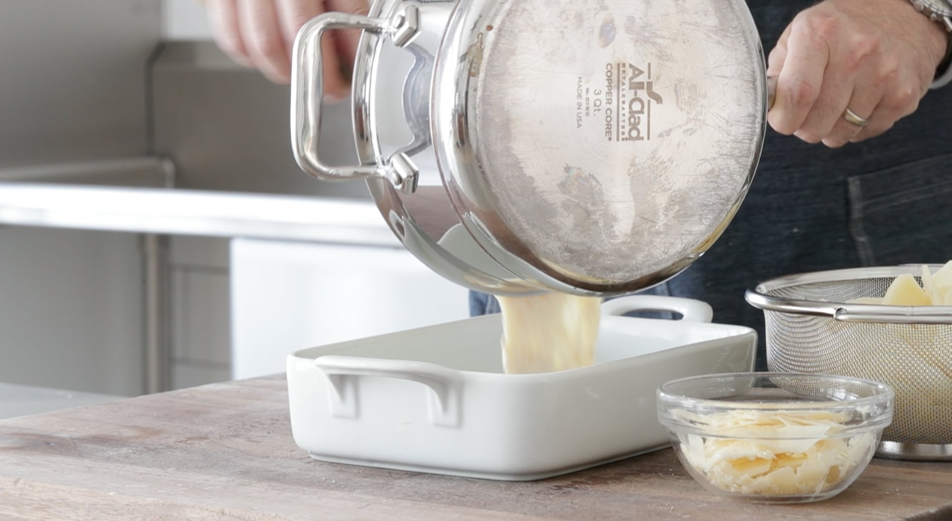 adding cheese sauce to a casserole dish