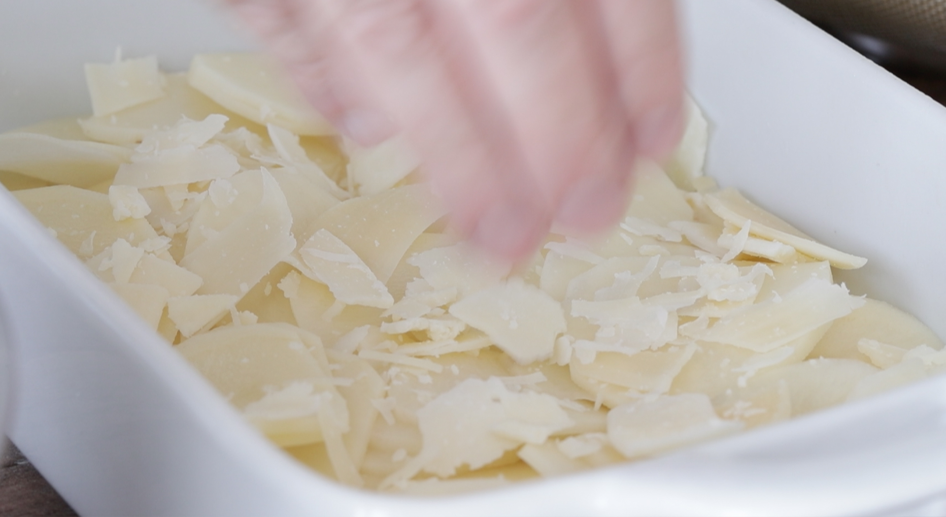 sprinkling cheese on potatoes