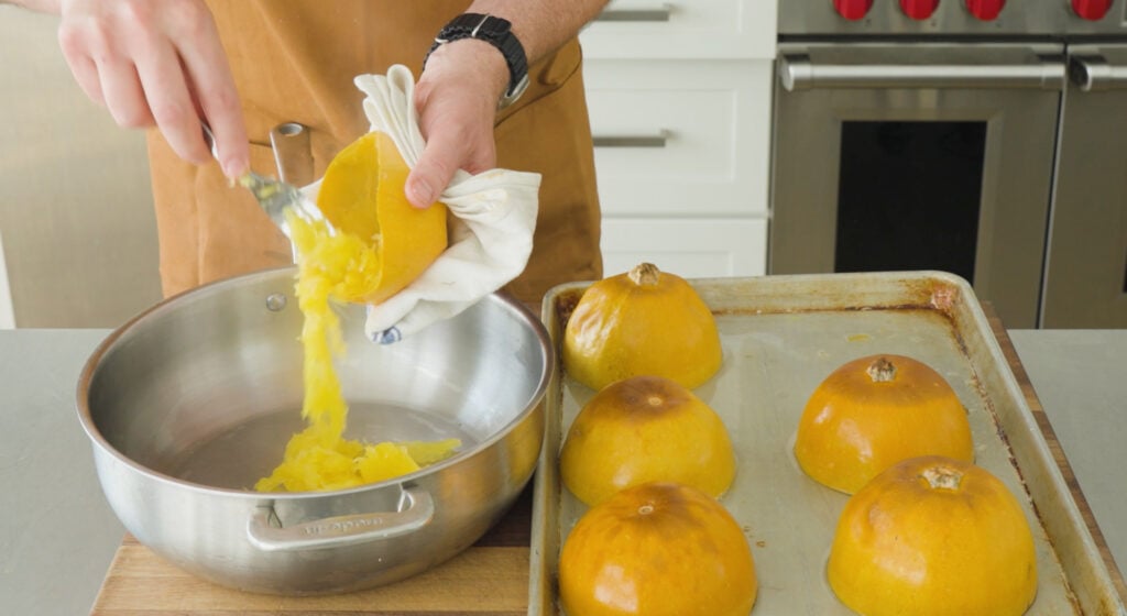 Scraping insides of squash into pot