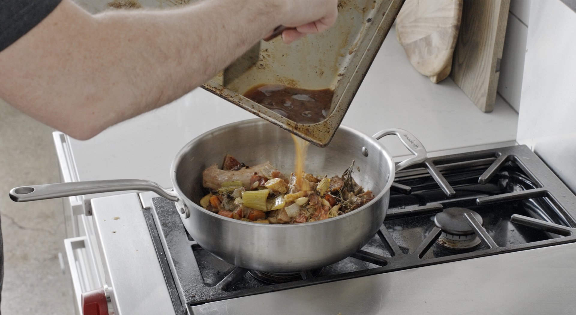 adding wine and fond to a pot of roasted veggies
