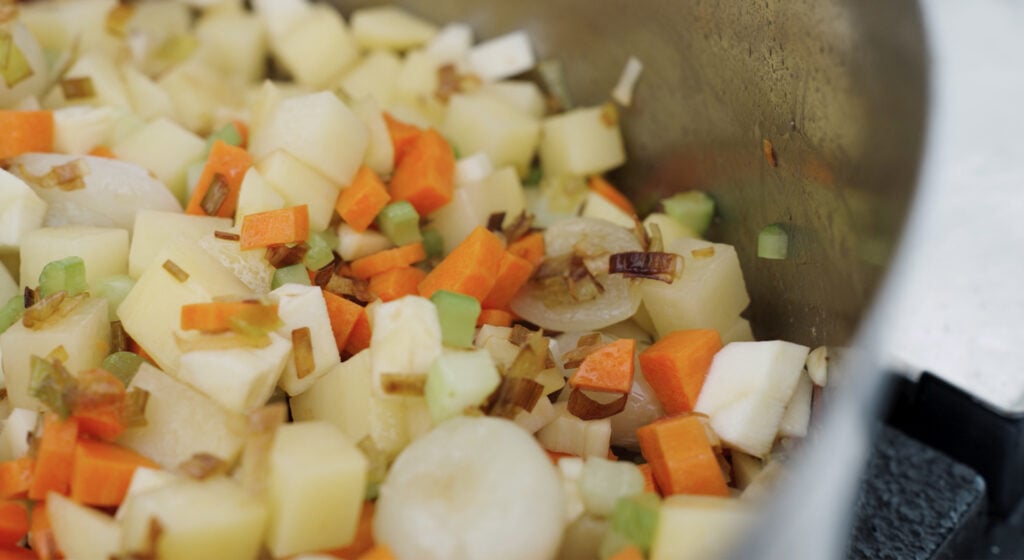 close up of vegetables added to the pot