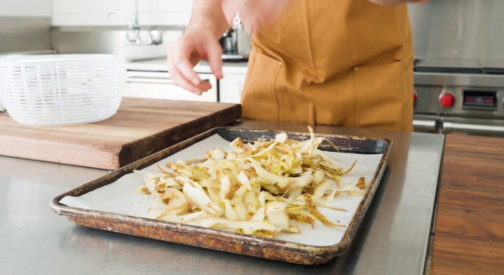 Potato skins spread on a parchment lined sheet tray