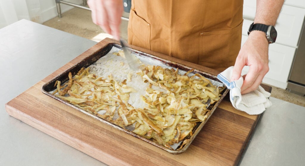 Mixing the potato skins on a sheet tray