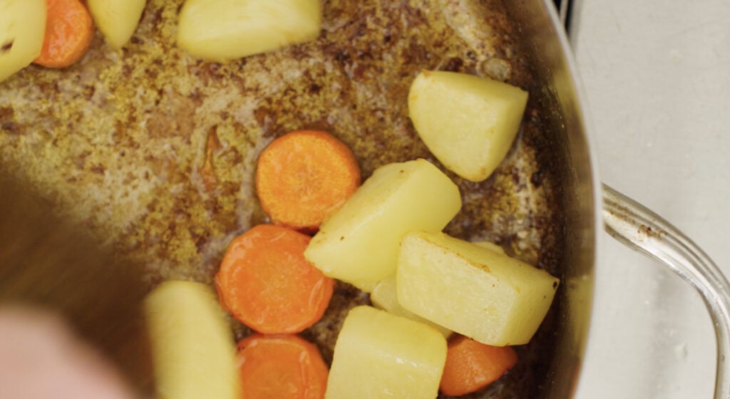 carrots and potatoes in pot with browned bottom