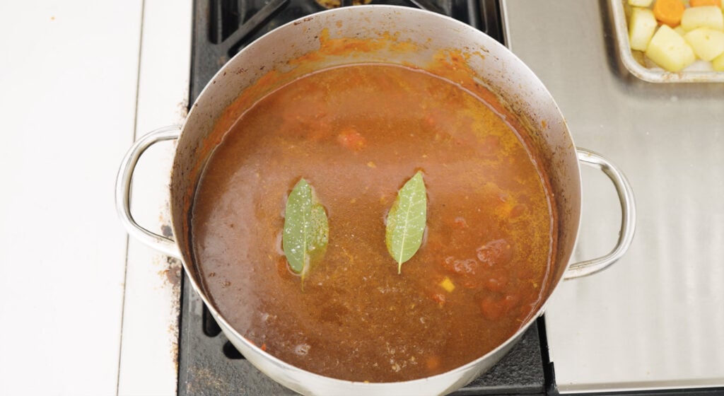 two pay leaves on top of sauce in large pot