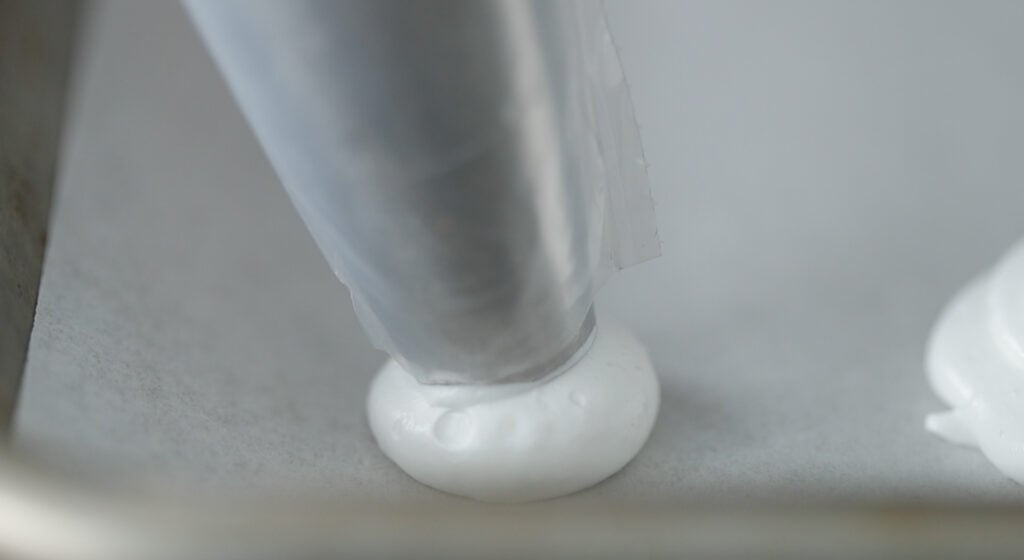 make round dollops using a circular motion onto a cookie sheet tray lined with parchment paper