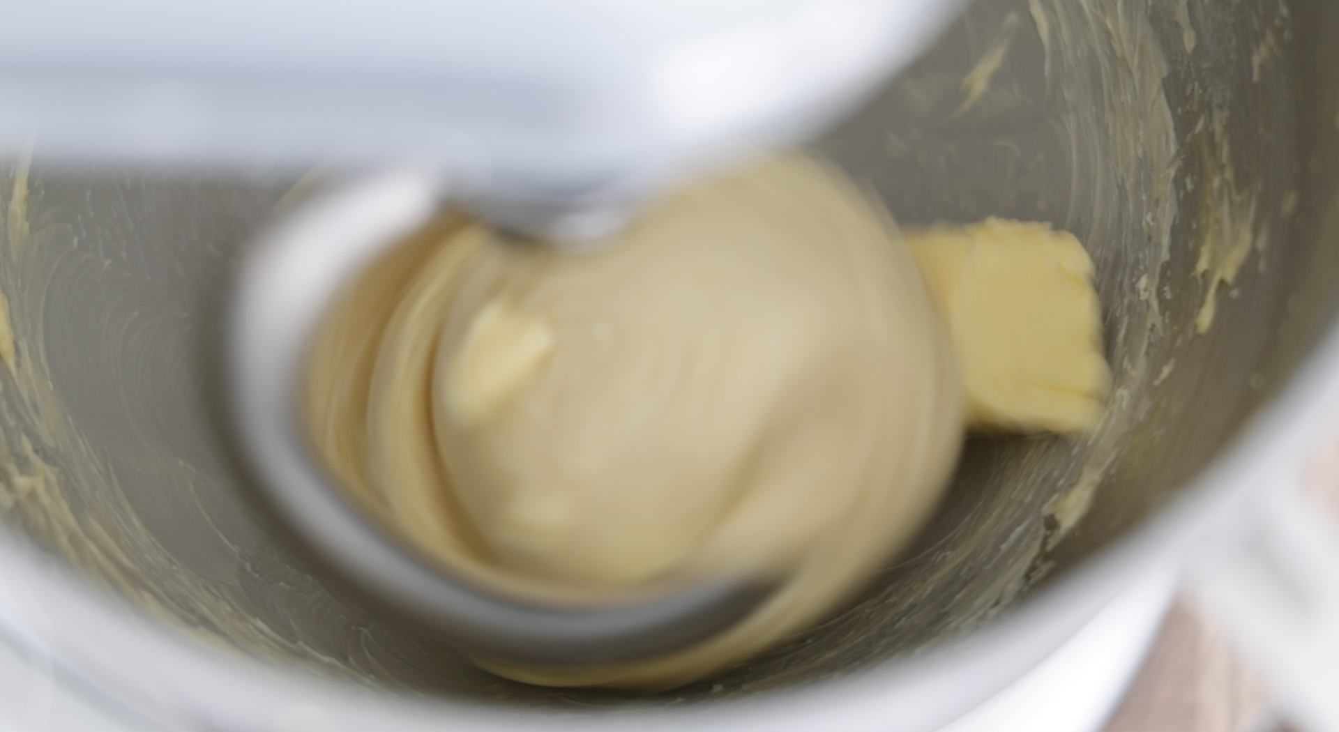 adding butter to a bowl of dough