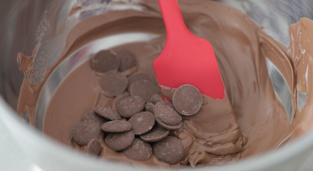 adding more chocolate to the and combine with spatula