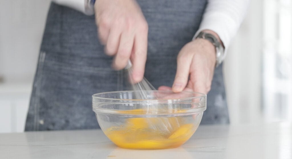 whisking together eggs in a bowl