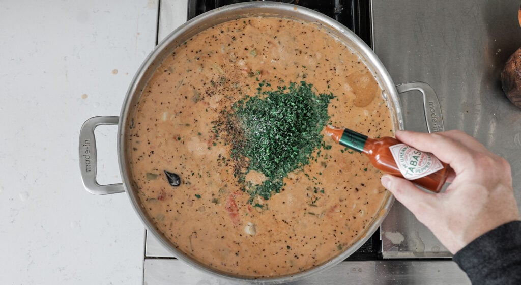 Adding tobasco to a pot of chowder