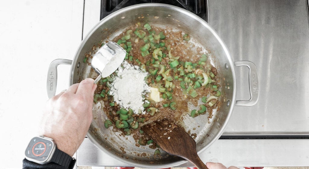 Pouring flour from a measuring cup into the rondeau pan