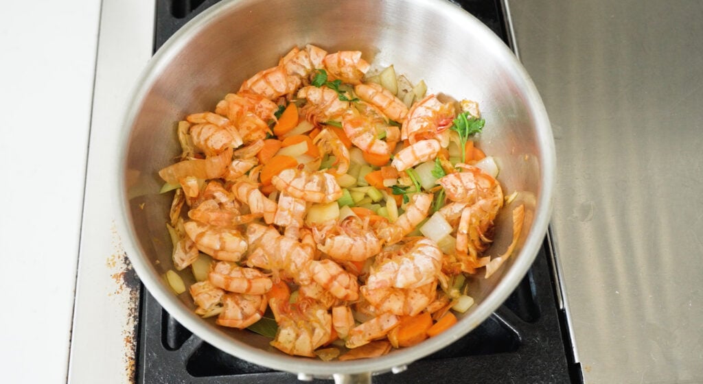 onion, carrot, celery, garlic, parsley stems, and shrimp shells in a pot