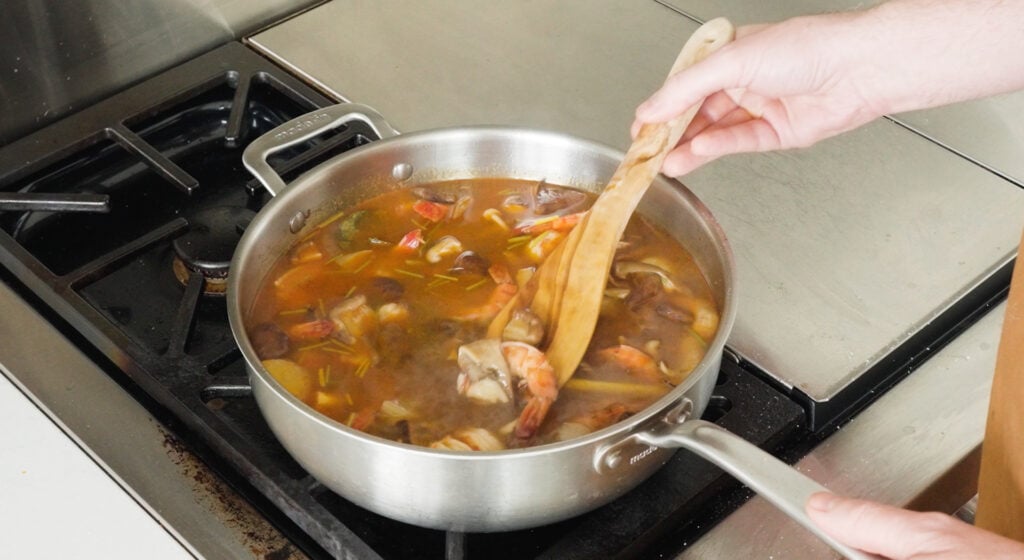 Stirring shrimp into the soup