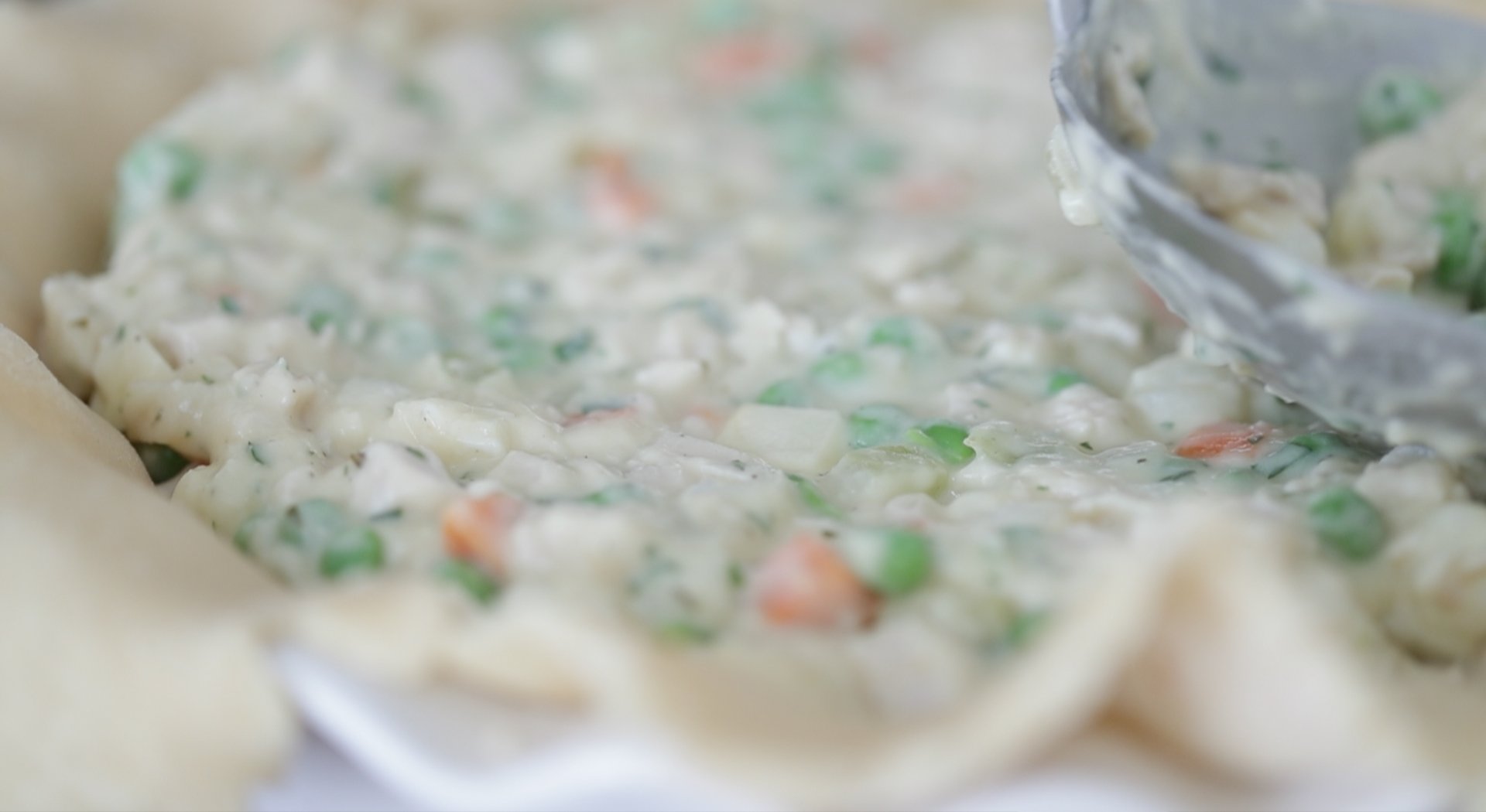 adding turkey pot pie filling into a pie