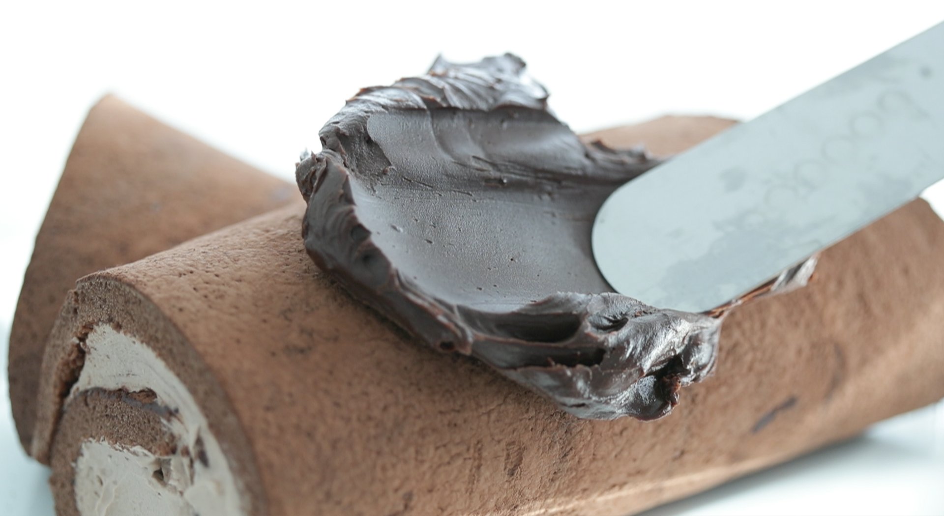 adding ganache to a roll cake