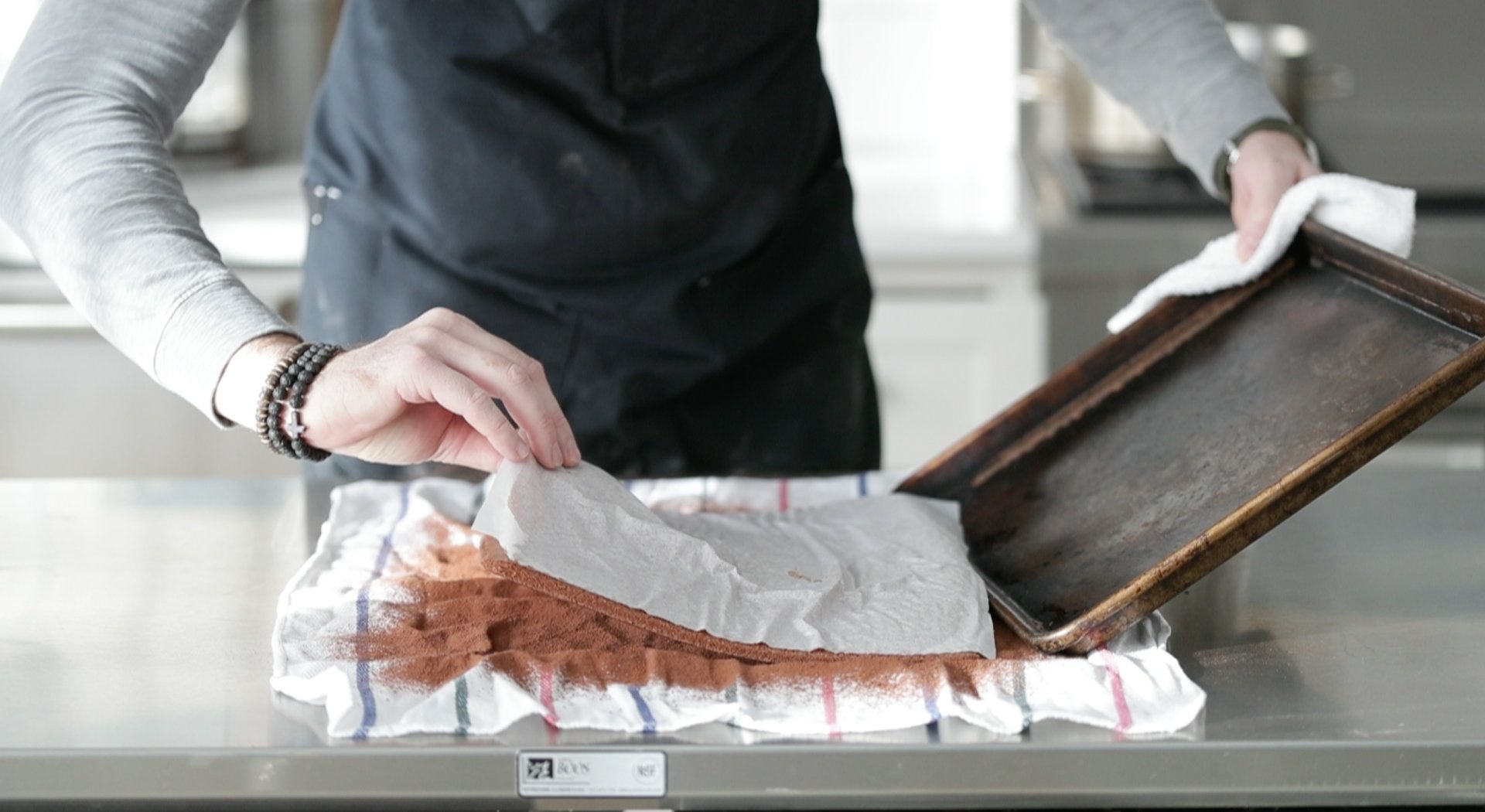 inverting a chocolate cake onto a cocoa dusted towel