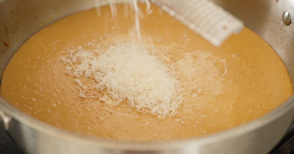 Finely grated cheese on top of the now blended ingredients in the pan