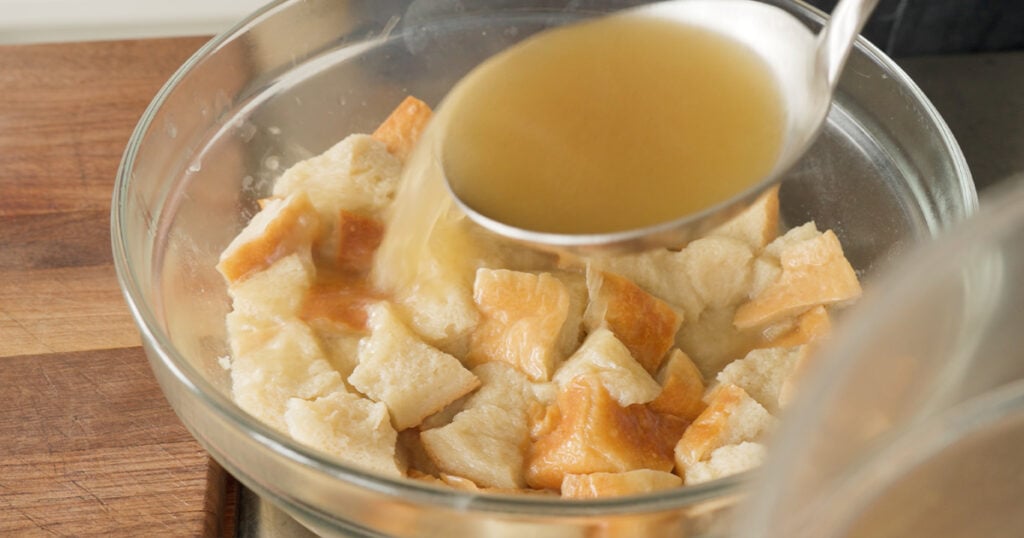 Pouring stock over pieces of bread