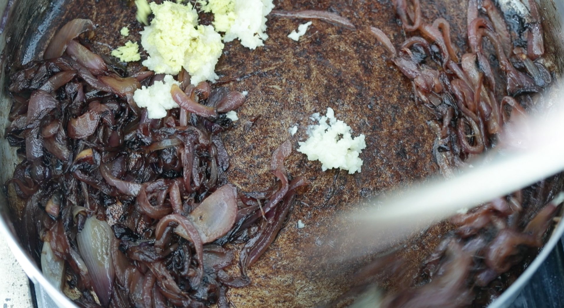 adding garlic and ginger to red onions