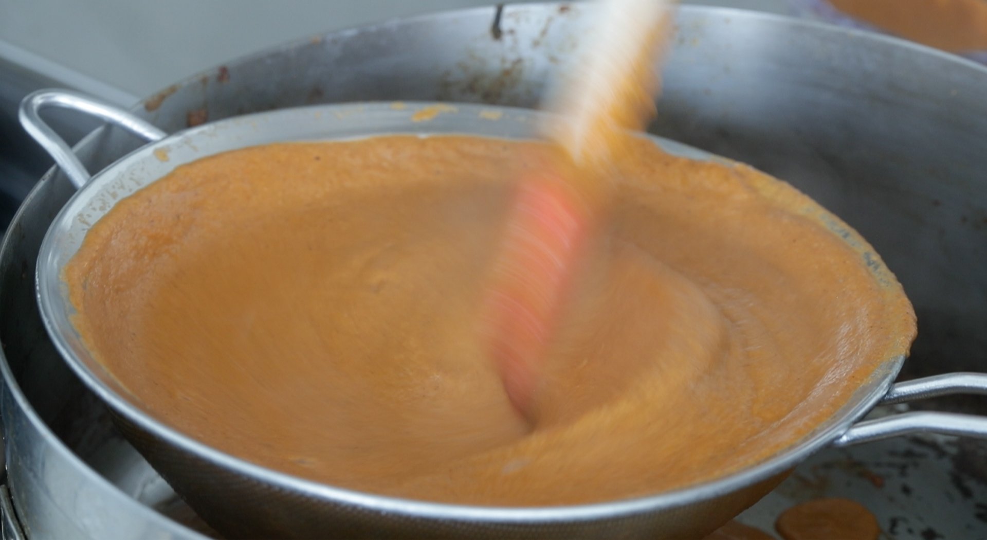 mixing together a sauce through a strainer