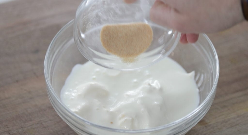 adding spices to a bowl of buttermilk and mayonnaise