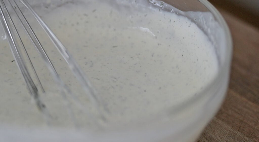 whisking a bowl of homemade ranch dressing