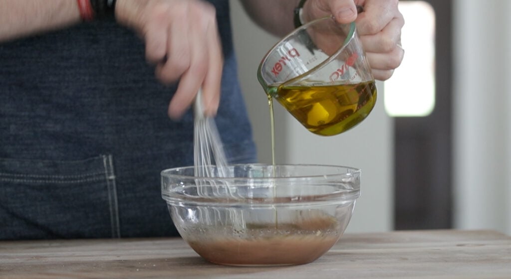 slowly drizzling in olive oil to a greek salad dressing
