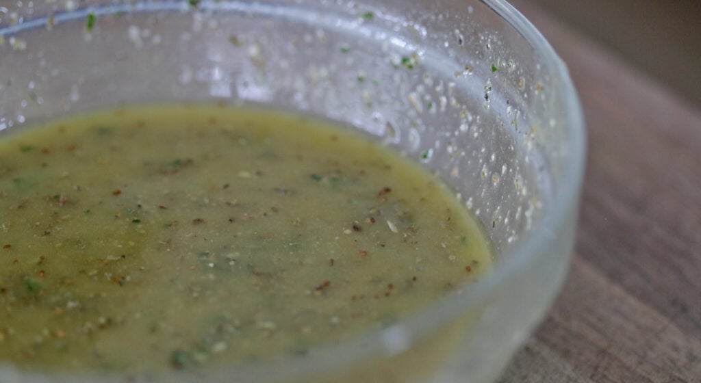 whisking together a Homemade Italian Dressing in a bowl