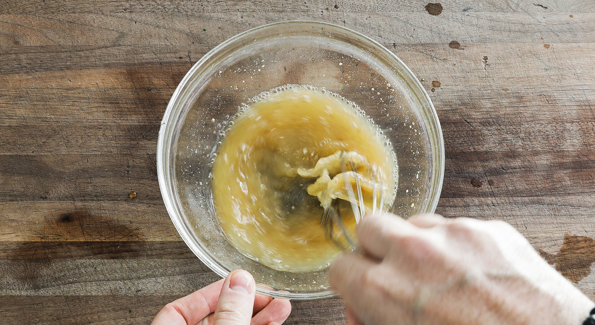 whisking lemon juice, vinegar, and mustard